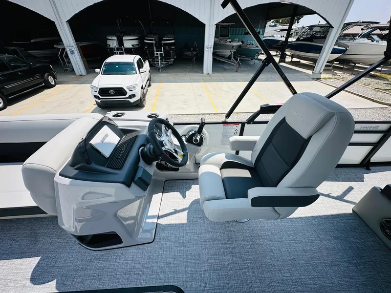 Slide: The Image of 2025 Harris Cruiser 230 boat interior with modern helm and comfortable seating. - 12