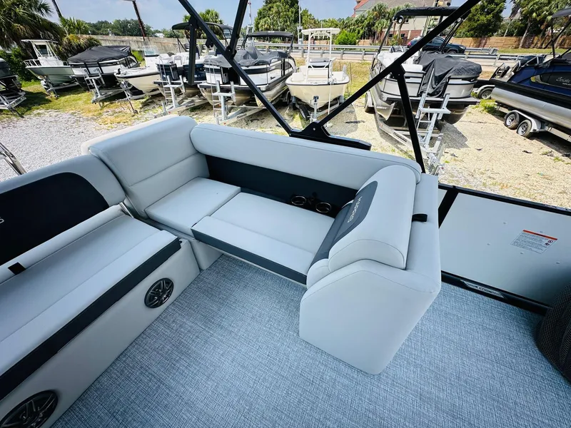 Slide: The Image of 2025 Harris Cruiser 230 boat interior with gray seating and outdoor view. - 14