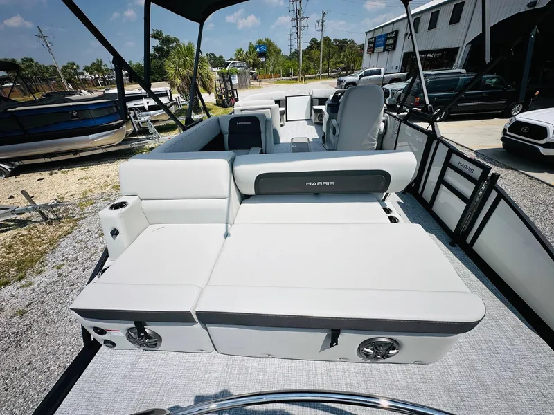 Slide: The Image of 2025 Harris Cruiser 230 boat with spacious seating and modern design, docked outdoors. - 17