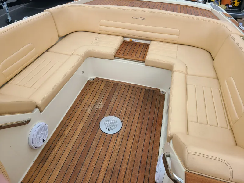 Slide: The Image of 2011 Chris-Craft Corsair 28 boat interior with beige seating and wooden flooring. - 11