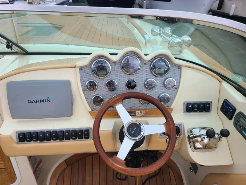 Slide: The Image of 2011 Chris-Craft Corsair 28 dashboard with Garmin navigation, wooden steering wheel, and control panel. - 6