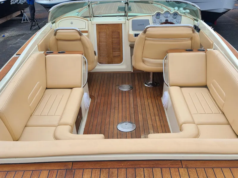 Slide: The Image of 2011 Chris-Craft Corsair 28 interior with tan leather seats and wooden flooring. - 9