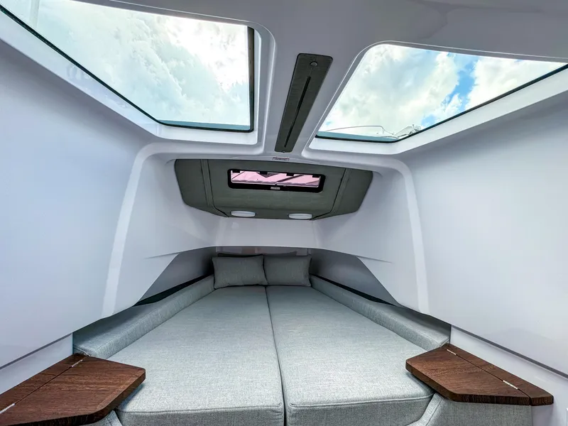 Slide: The Image of 2024 Axopar 37XC CROSS CABIN interior with skylights and modern bedding. - 12