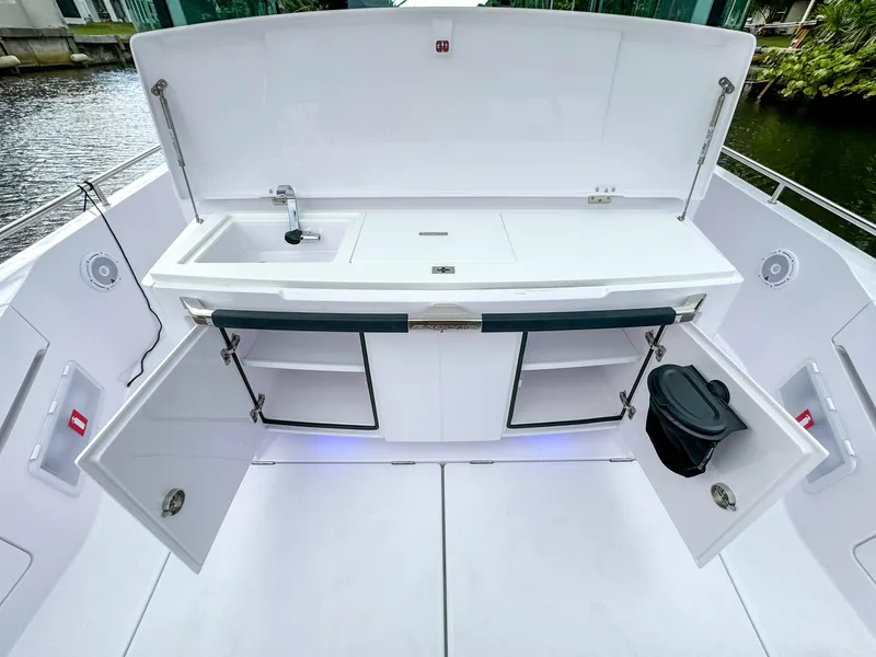 Slide: The Image of 2024 Axopar 37XC CROSS CABIN boat kitchen with open storage and sink. - 20