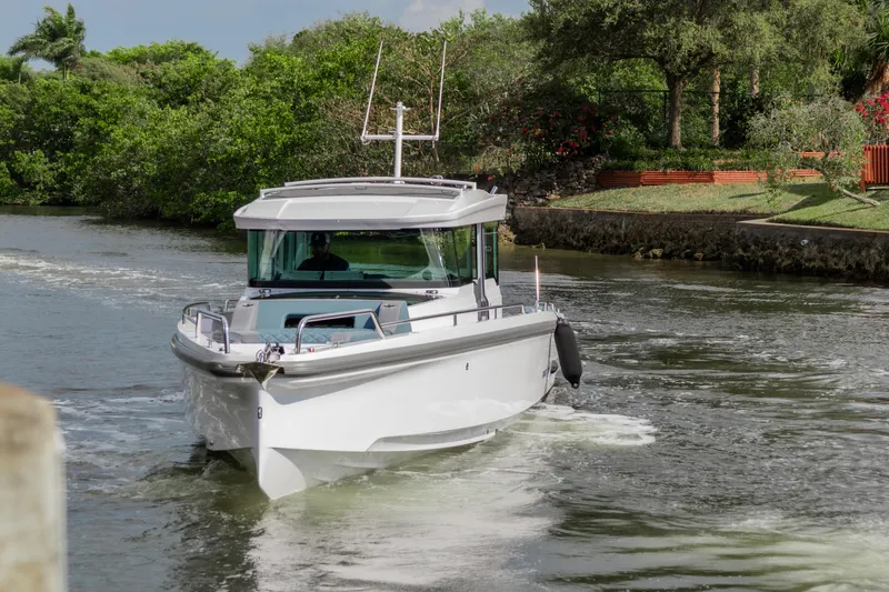 Slide: The Image of 2024 Axopar 37XC CROSS CABIN boat cruising on a scenic waterway. - 24