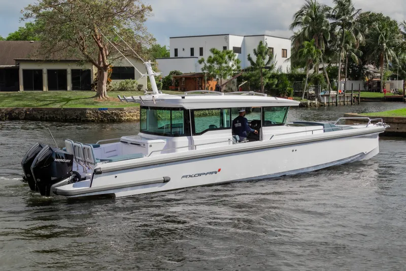 Slide: The Image of 2024 Axopar 37XC CROSS CABIN cruising on a scenic waterway. - 5