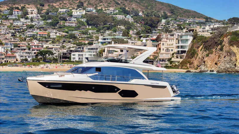 Slide: The Image of Luxury Absolute 58 FLY yacht cruising near scenic coastal homes, 2019 model. - 16