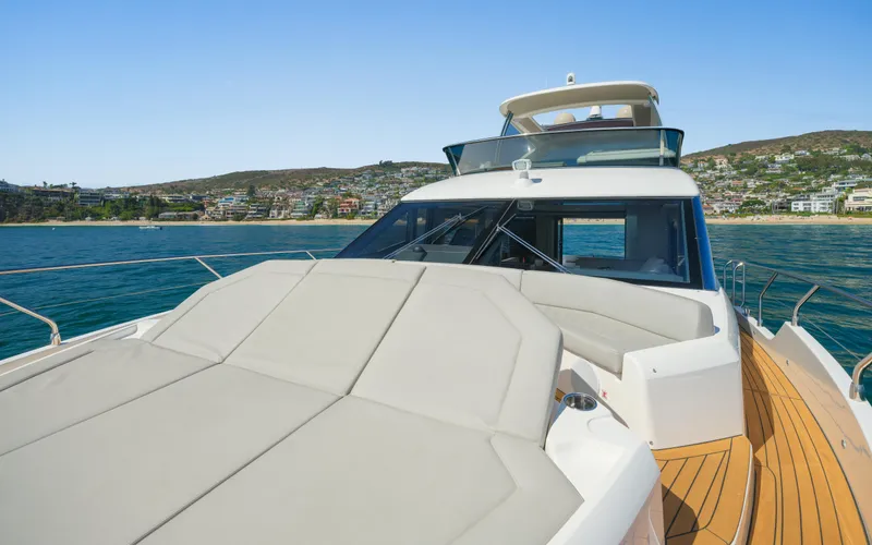 Slide: The Image of Luxurious 2019 Absolute 58 FLY yacht on serene waters with scenic coastal backdrop. - 28