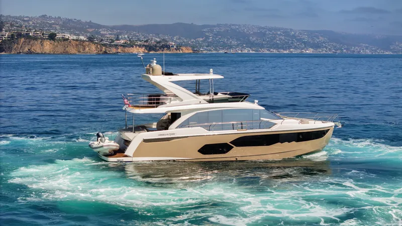 Slide: The Image of Luxurious 2019 Absolute 58 FLY yacht cruising on the ocean with scenic coastal backdrop. - 9