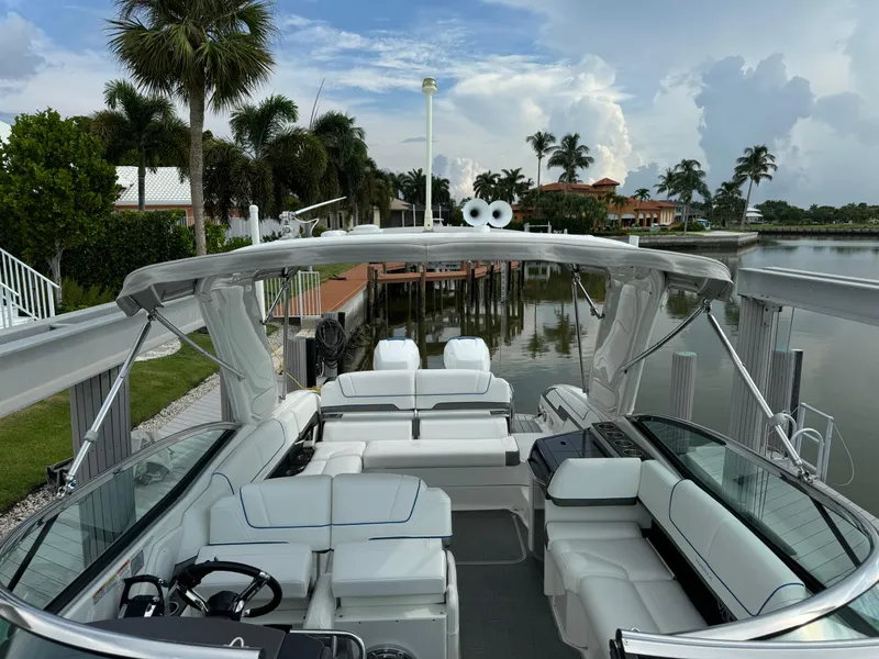 Slide: The Image of 2019 Formula 310 Bowrider OB, luxurious seating, docked by palm trees and waterfront homes. - 30