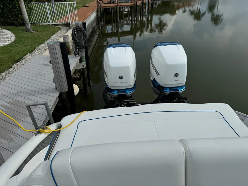 Slide: The Image of 2019 Formula 310 Bowrider OB with dual outboard engines docked by a calm waterfront. - 40