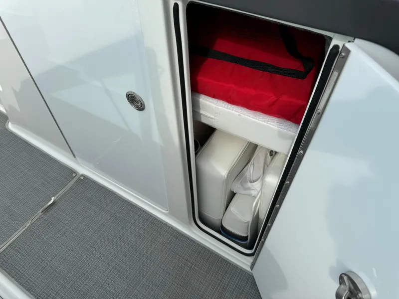 Slide: The Image of Storage compartment on 2019 Formula 310 Bowrider OB, featuring organized interior with red bag. - 47