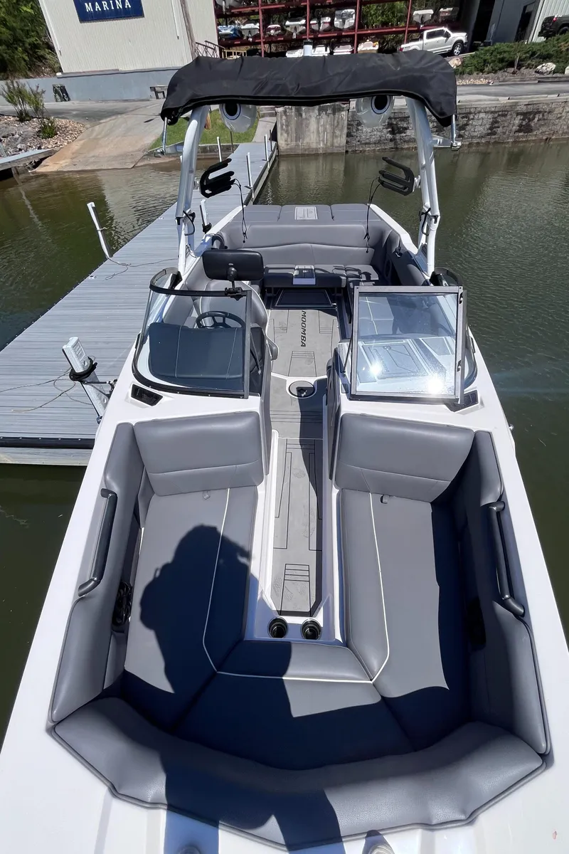 Slide: The Image of 2024 Moomba Max boat with sleek gray interior, docked at a marina. - 11