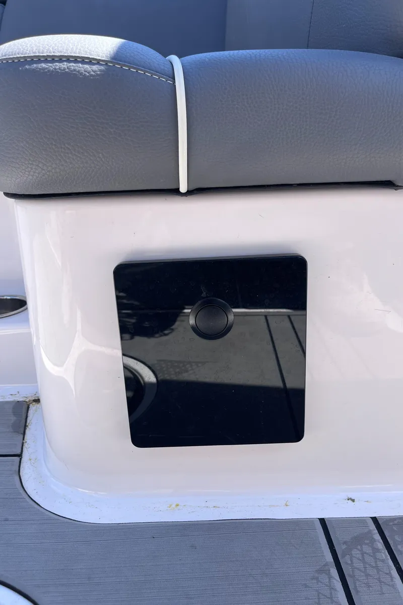 Slide: The Image of 2024 Moomba Max boat interior detail with sleek black panel and gray seating. - 24