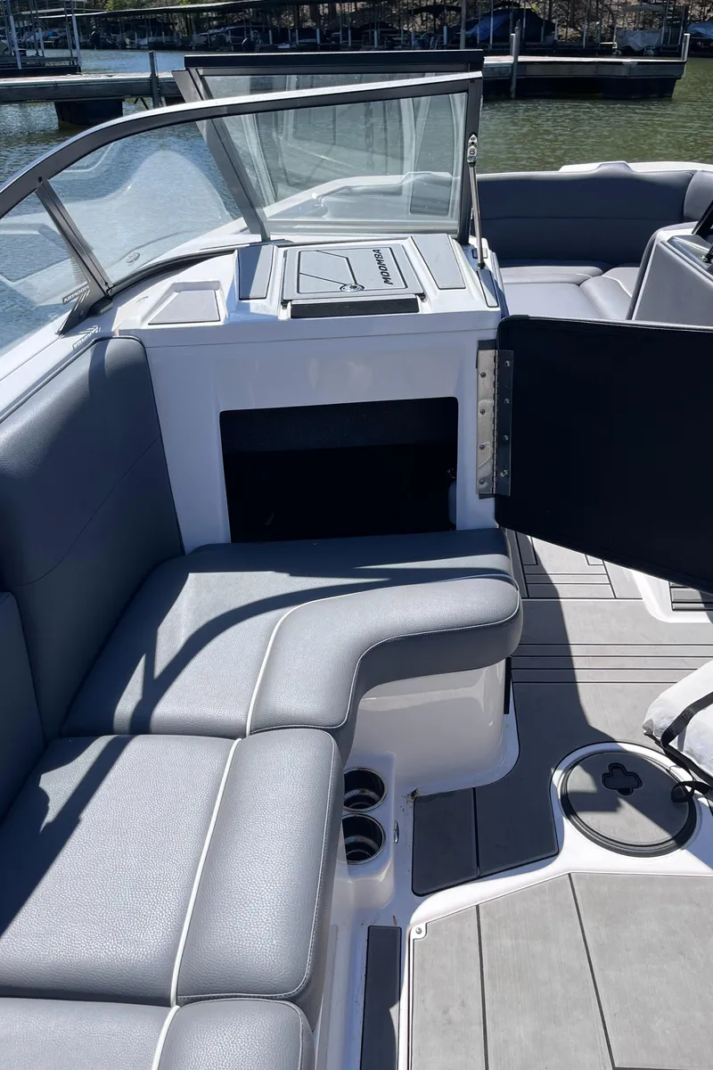 Slide: The Image of 2024 Moomba Max boat interior with gray seating and open storage compartment. - 29