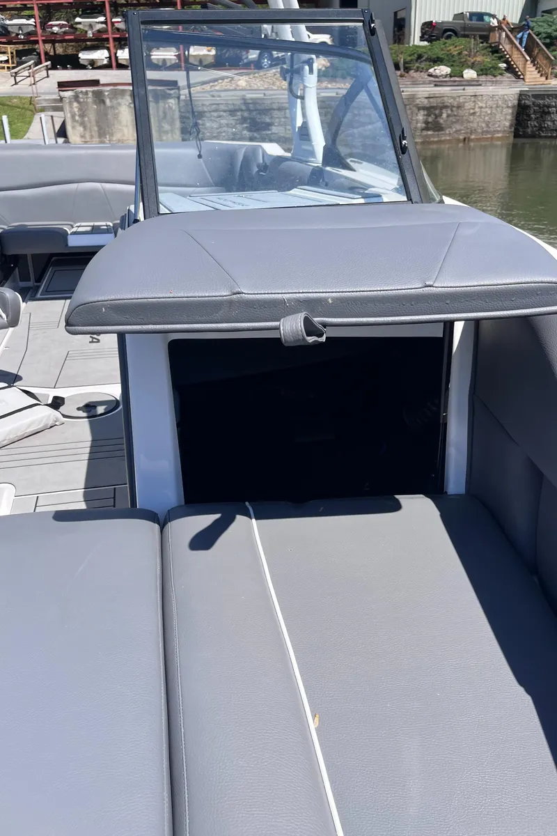 Slide: The Image of 2024 Moomba Max boat interior with gray seating and open storage compartment. - 34