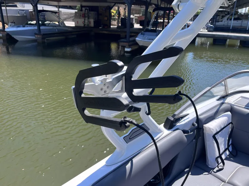Slide: The Image of 2024 Moomba Max boat with wakeboard rack, docked by the water. - 35