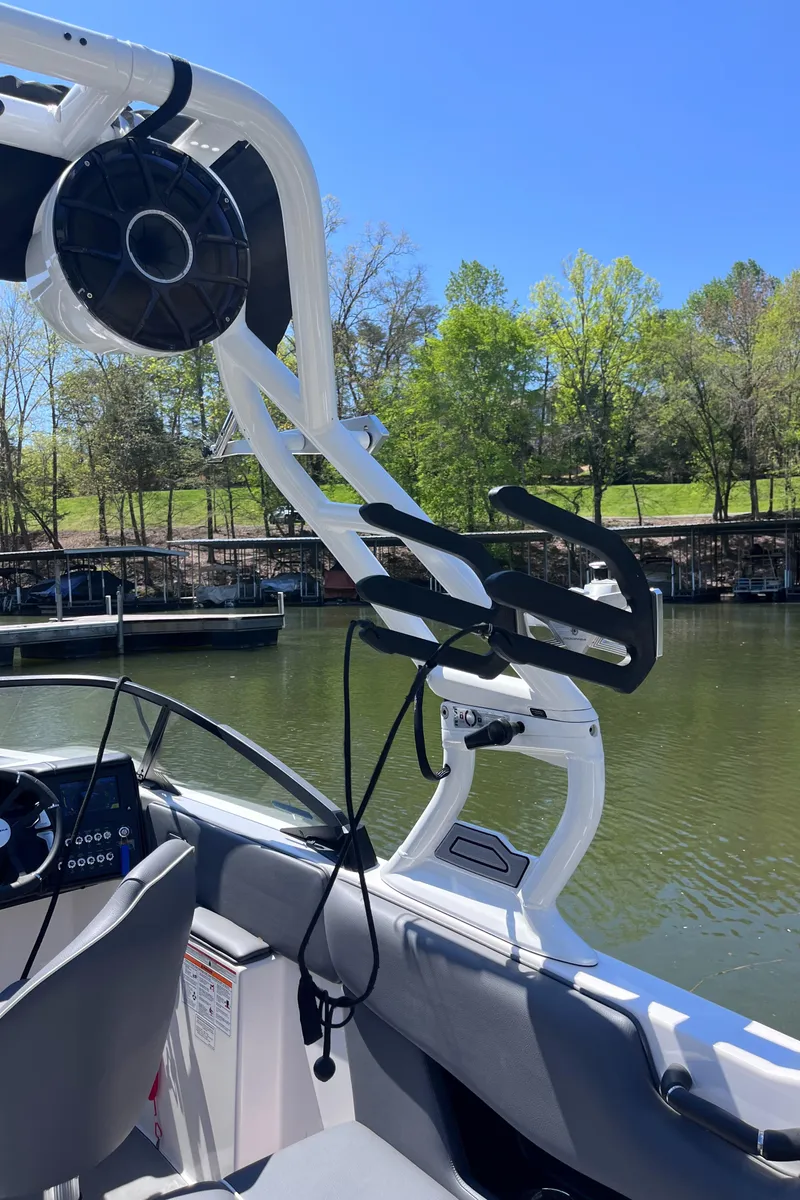 Slide: The Image of 2024 Moomba Max boat interior with wakeboard tower on a sunny day by the lake. - 36