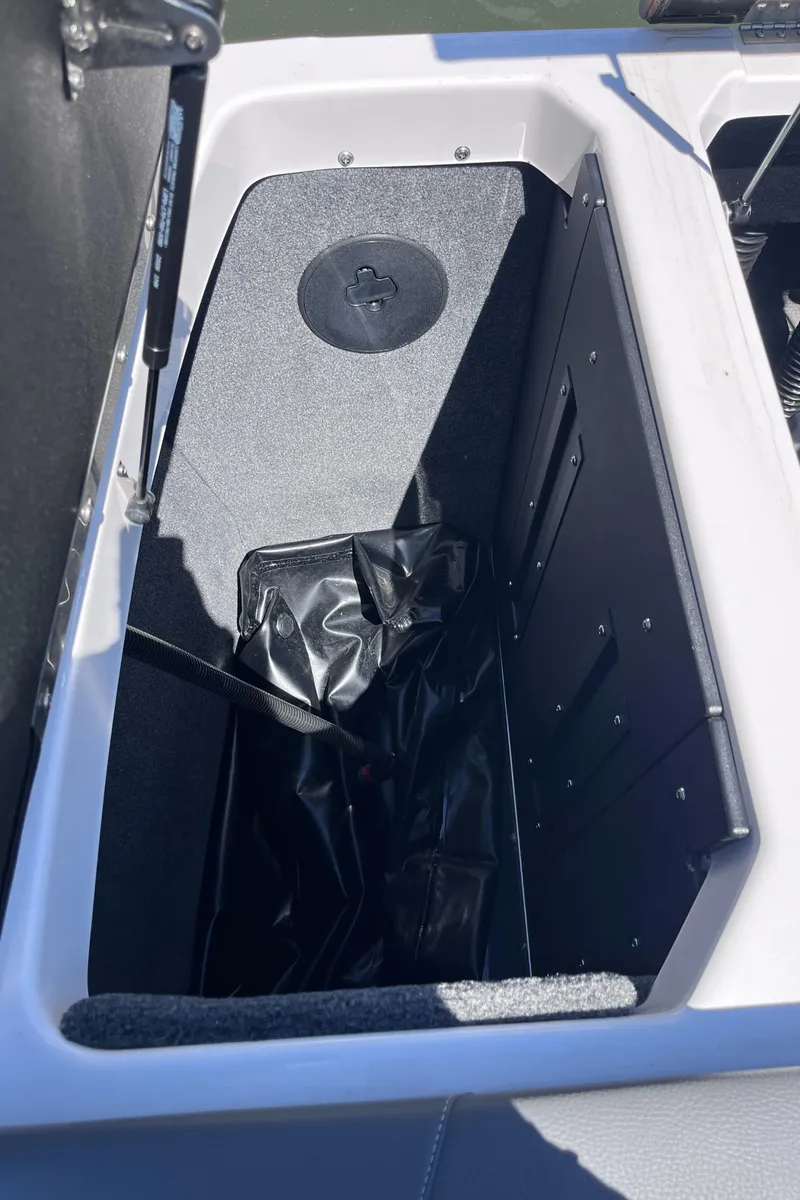 Slide: The Image of 2024 Moomba Max storage compartment with black interior and secure latch. - 38