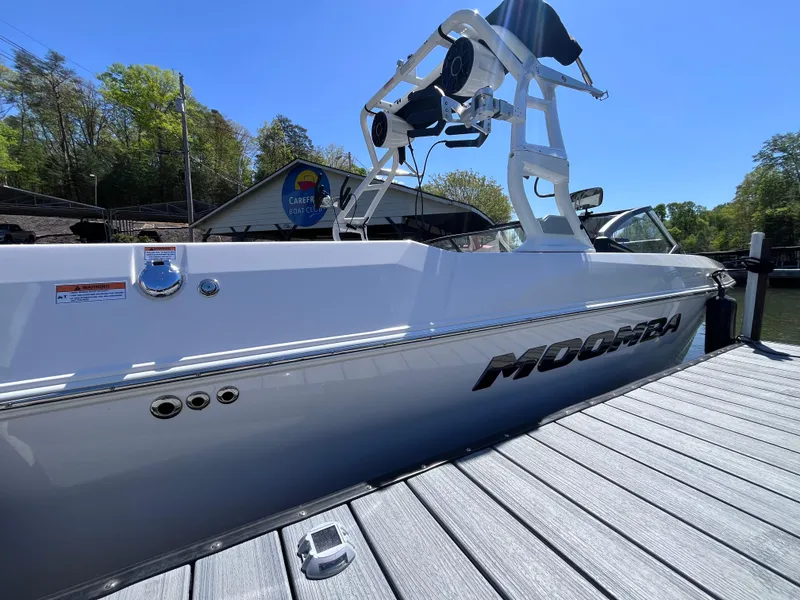 Slide: The Image of 2024 Moomba Max boat docked, showcasing sleek design and modern features under a clear blue sky. - 4