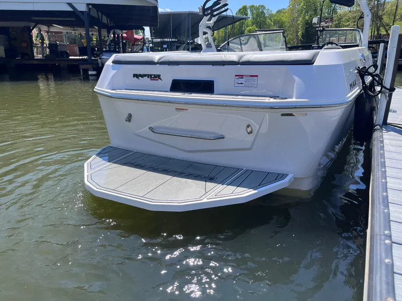 Slide: The Image of 2024 Moomba Max boat docked on calm water, rear view. - 5