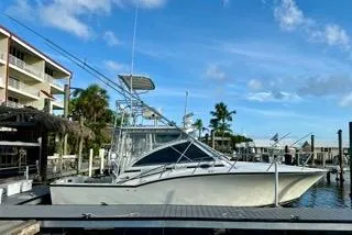 Slide: The Image of 2001 Carolina Classic 35 boat docked at marina under clear blue sky. - 0