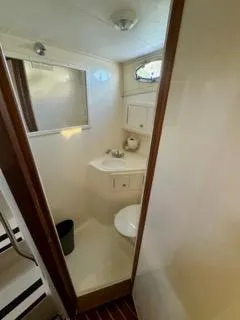 Slide: The Image of 2001 Carolina Classic 35 boat bathroom with sink, toilet, and storage cabinets. - 21