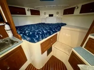 Slide: The Image of 2001 Carolina Classic 35 cabin interior with bed, wooden cabinets, and compact sink area. - 23