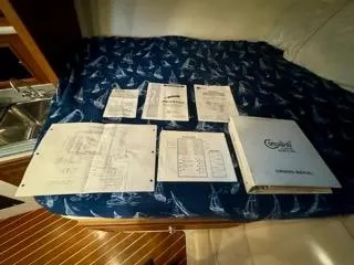 Slide: The Image of Carolina Classic 35, 2001 manuals and schematics on a nautical-themed bedspread. - 30