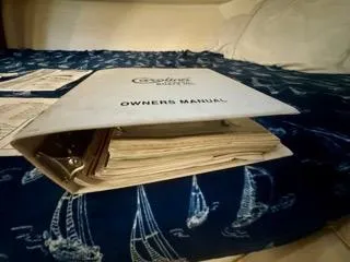 Slide: The Image of Carolina Classic 35 2001 owner's manual on a nautical-themed bedspread. - 31