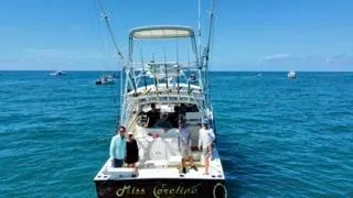 Slide: The Image of 2001 Carolina Classic 35 boat on open sea with people onboard. - 4