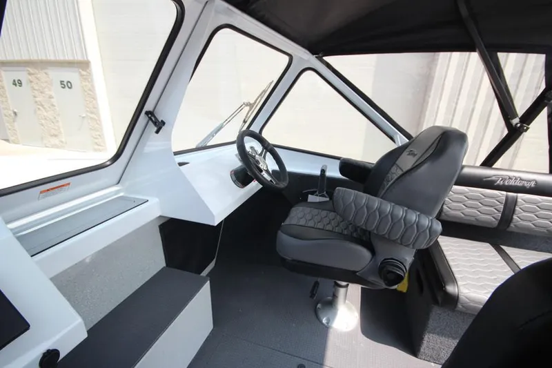 Slide: The Image of 2025 Weldcraft 200 Rebel F150 boat interior with steering wheel and cushioned seating. - 20