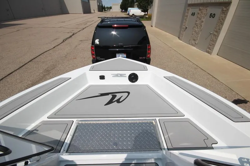 Slide: The Image of 2025 Weldcraft 200 Rebel F150 boat on trailer, parked near industrial buildings. - 27