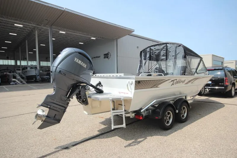 Slide: The Image of 2025 Weldcraft 200 Rebel F150 boat with Yamaha engine, parked outdoors. - 4