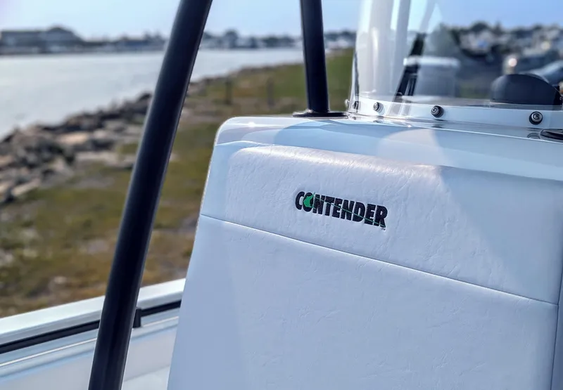 Slide: The Image of 2025 Contender 24 Sport boat seat with logo, near a scenic waterfront. - 14