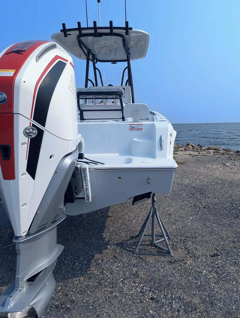 Slide: The Image of 2025 Contender 24 Sport boat with powerful outboard motor by the shore. - 15