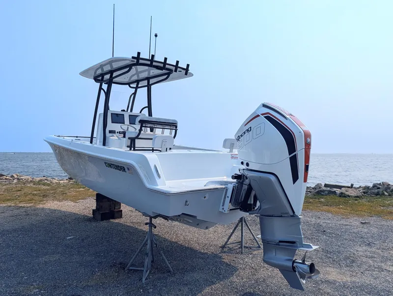 Slide: The Image of 2025 Contender 24 Sport boat with outboard motor, displayed near a waterfront. - 16