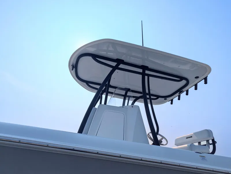 Slide: The Image of 2025 Contender 24 Sport boat with sleek T-top design against clear blue sky. - 19