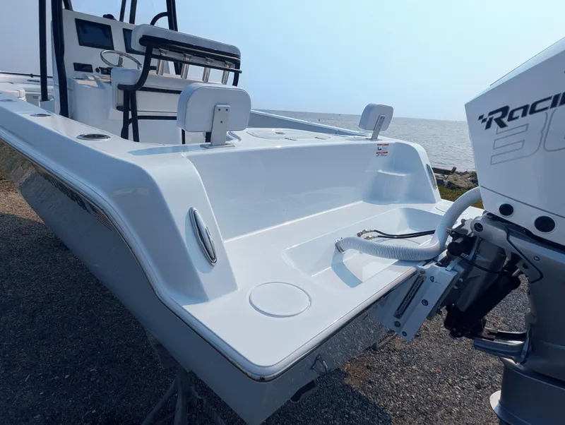 Slide: The Image of 2025 Contender 24 Sport boat with powerful outboard motor, docked by the shore. - 21