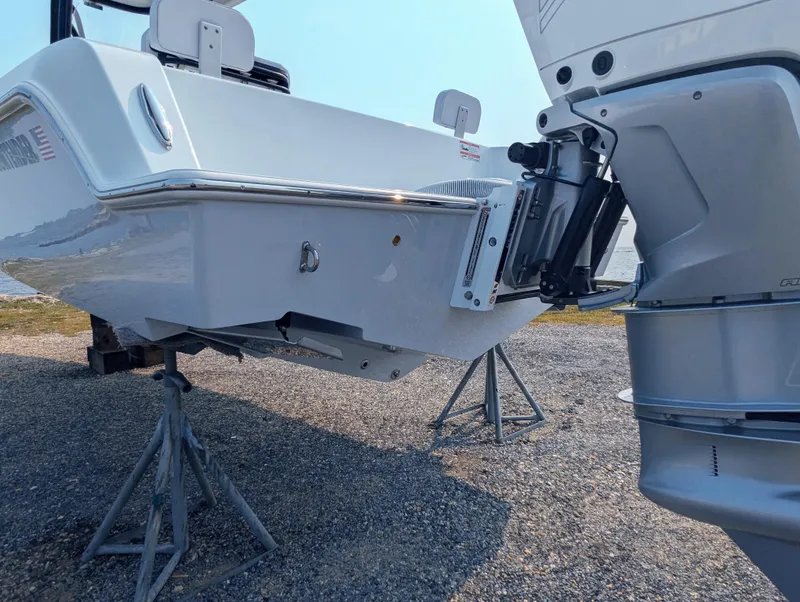 Slide: The Image of 2025 Contender 24 Sport boat on stands, showcasing rear and engine details. - 22