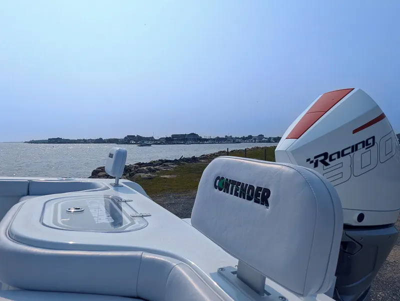 Slide: The Image of Contender 24 Sport 2025 boat with powerful engine, near a scenic waterfront. - 29