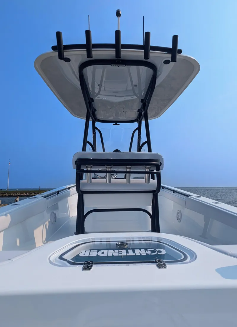 Slide: The Image of 2025 Contender 24 Sport boat with T-top, viewed from the bow, under a clear blue sky. - 36