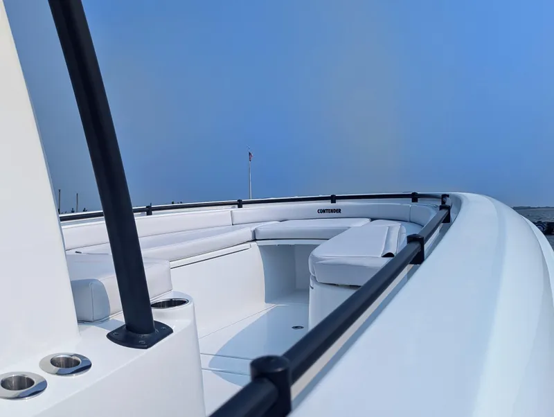 Slide: The Image of 2025 Contender 24 Sport boat with sleek white interior and seating, under clear blue sky. - 41