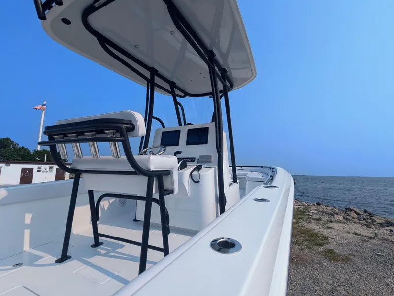 Slide: The Image of 2025 Contender 24 Sport boat docked by the sea, featuring sleek design and modern controls. - 44