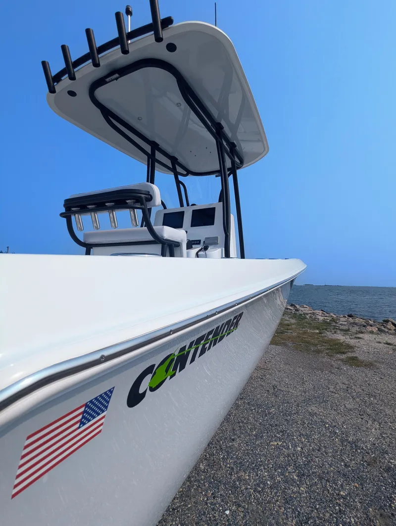Slide: The Image of 2025 Contender 24 Sport boat by the shore, featuring sleek design and American flag decal. - 45