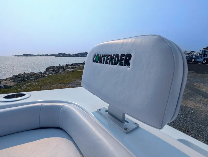Slide: The Image of 2025 Contender 24 Sport boat seat with logo, near a scenic waterfront. - 9