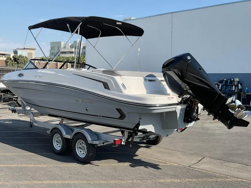 Slide: The Image of 2025 Bayliner VR6 Bowrider OB on trailer with canopy, parked outdoors. - 2