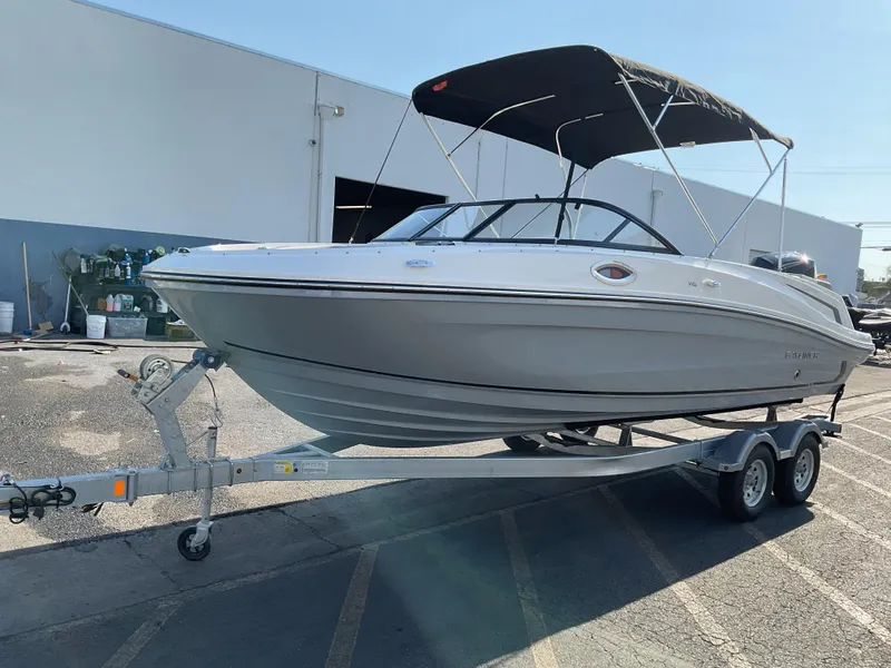 Slide: The Image of 2025 Bayliner VR6 Bowrider OB on trailer, parked outdoors with a bimini top. - 4