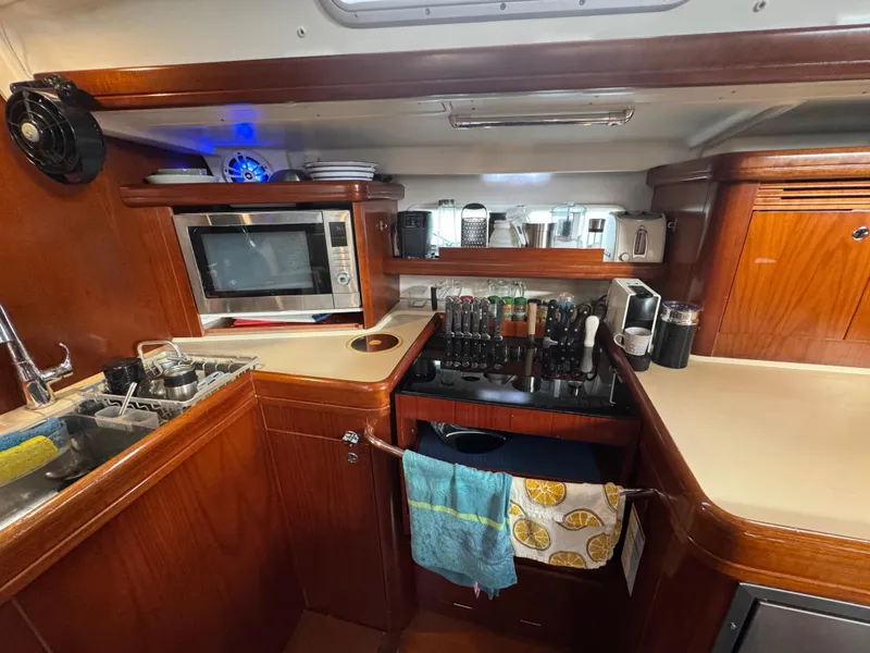 Slide: The Image of Galley of 2005 Beneteau 523 Oceanis yacht with wooden cabinetry and modern appliances. - 11