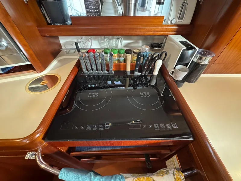 Slide: The Image of Galley kitchen in 2005 Beneteau 523 Oceanis with induction cooktop and utensils. - 12